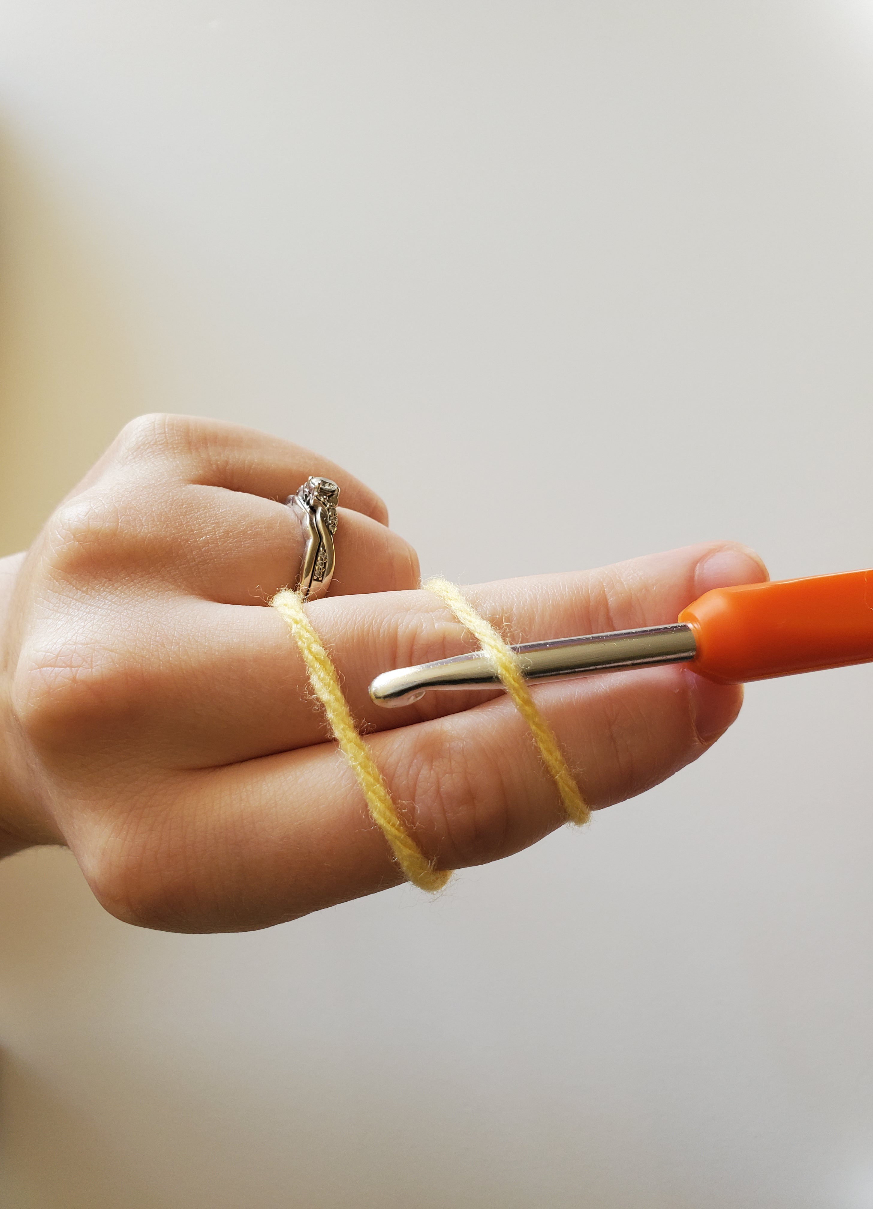 Inserting crochet hook under and over strands of yarn
