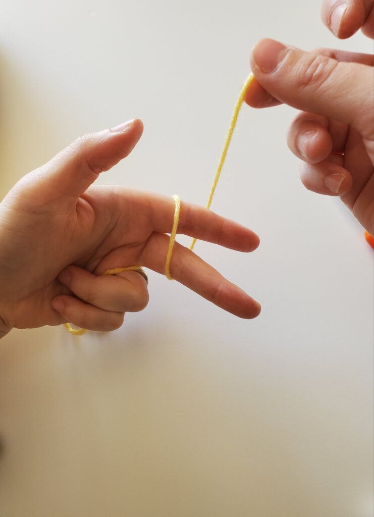 Pulling yarn around two fingers again