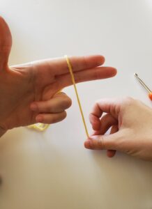 Pulling yarn up and over two fingers