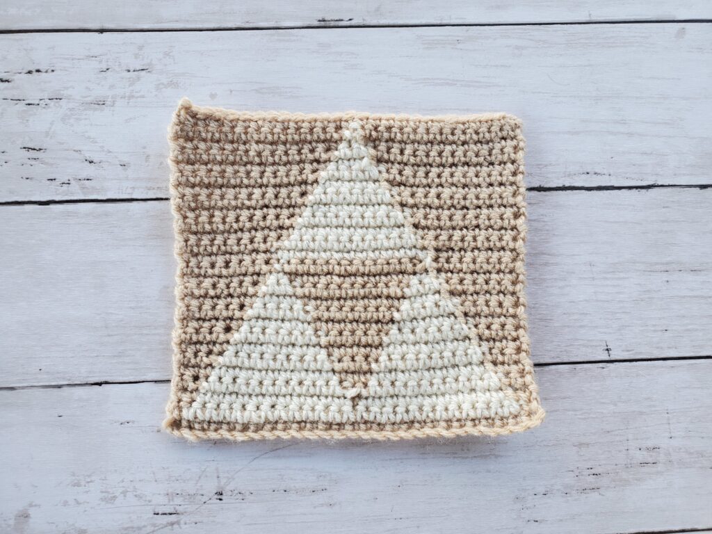 Crochet triforce dishcloth with buff base color and aran for triforce