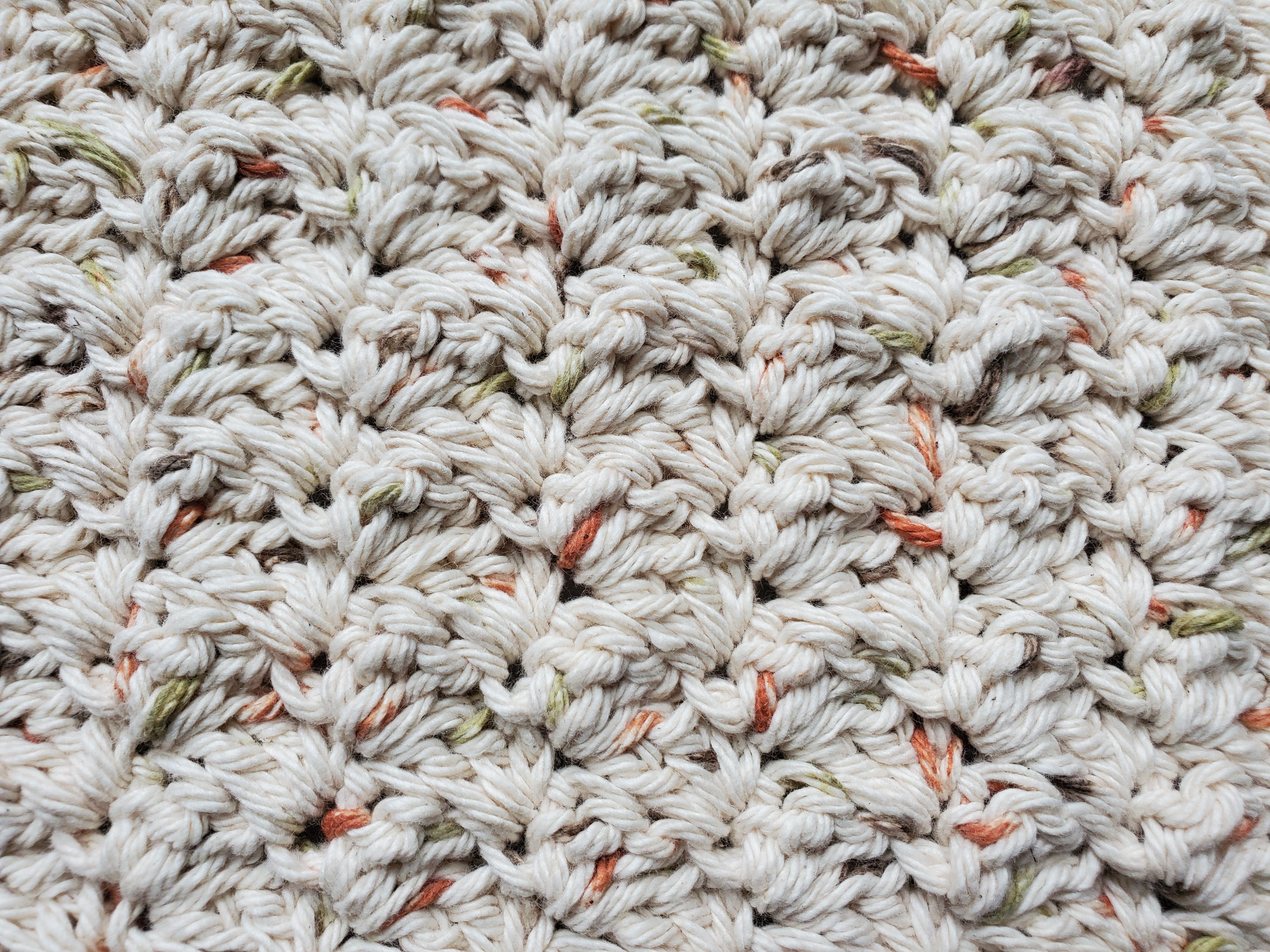 Close up of textured dishcloth in peaches and creme oasis cotton yarn